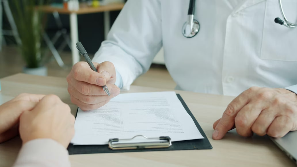 Adult care discută cu un medic într-un cabinet luminos